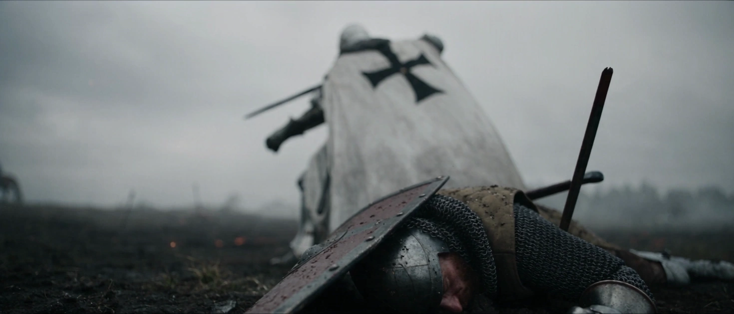 A knight in a white cloak on a misty battlefield