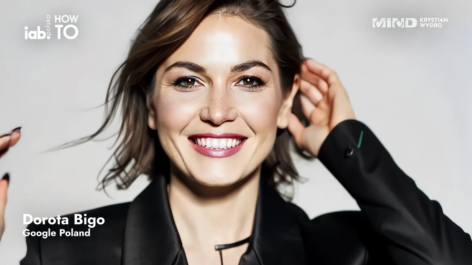 A smiling speaker against a light background