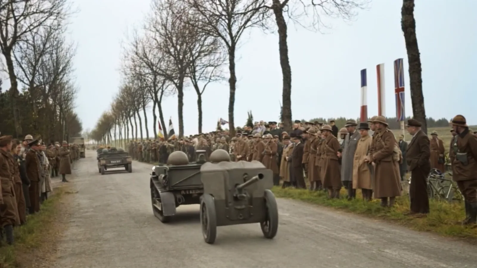 A column of people and vehicles on a tree-lined road