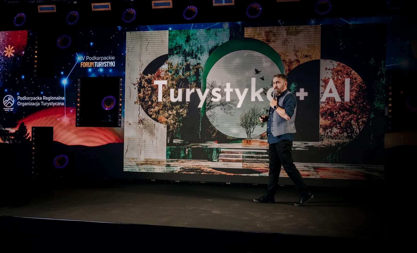 Krystian Wydro on stage at IV Podkarpackie Forum Turystyki, with a “Turystyka + AI” (Tourism + AI) slide on the screen